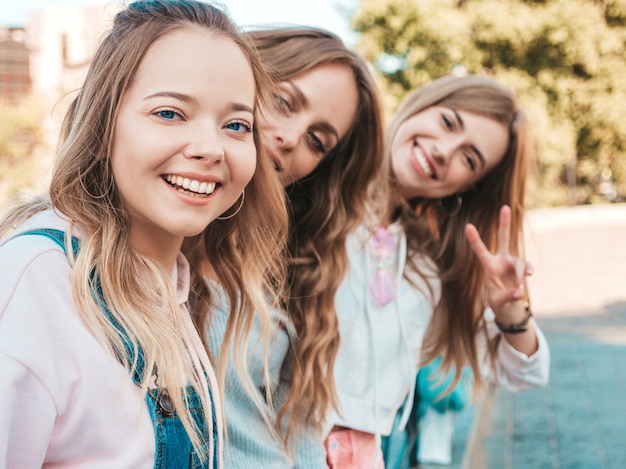 Portrait of  Sexy carefree women posing on the street background.Positive models having fun.Hugging