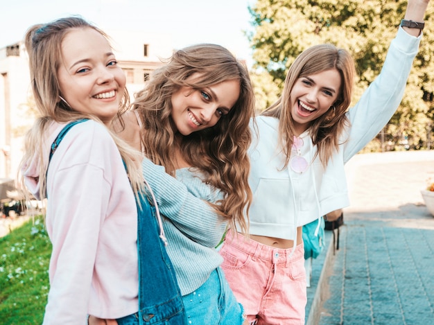 Portrait of  Sexy carefree women posing on the street background.Positive models having fun.Hugging