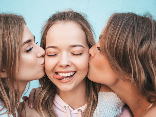 Free photo portrait of  sexy carefree women posing in the street.positive models kissing their friend in cheek