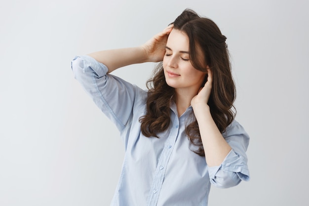 Portrait of sexy girl with dark wavy hair and closed eyes,trying to wake up in early morning after two weeks of vacation.