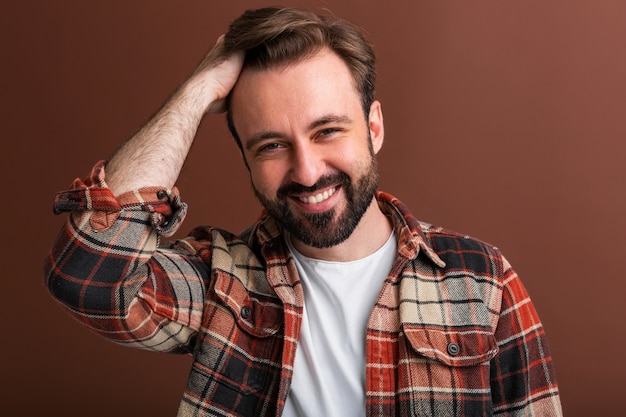 Портрет сексуального красивого привлекательного стильного бородатого мужчины на коричневом