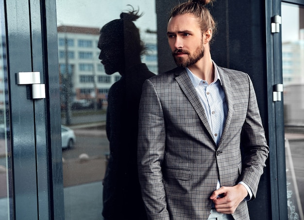 Portrait of sexy handsome man dressed in elegant beige checkered suit