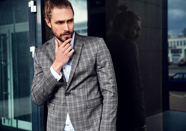 Portrait of sexy handsome man dressed in elegant beige checkered suit