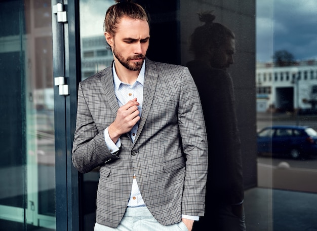 Portrait of sexy handsome man dressed in elegant beige checkered suit