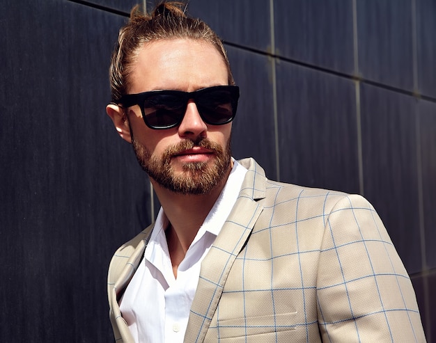 Portrait of sexy handsome man dressed in elegant beige checkered suit