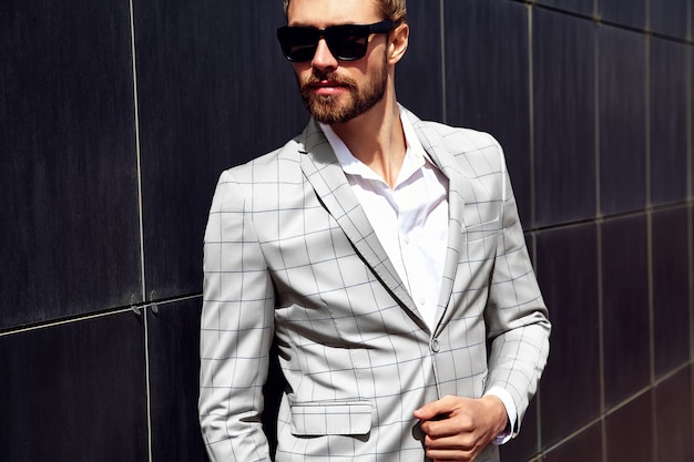 Portrait of sexy handsome man dressed in elegant beige checkered suit