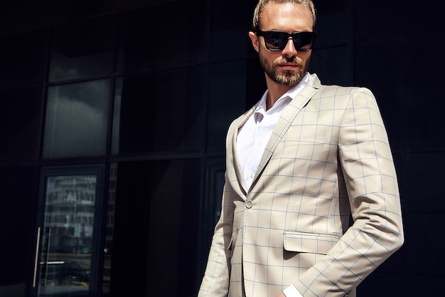 Free photo portrait of sexy handsome man dressed in elegant beige checkered suit