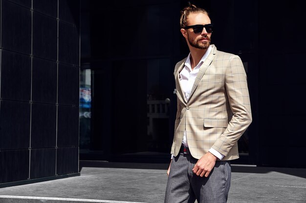 Portrait of sexy handsome man dressed in elegant beige checkered suit