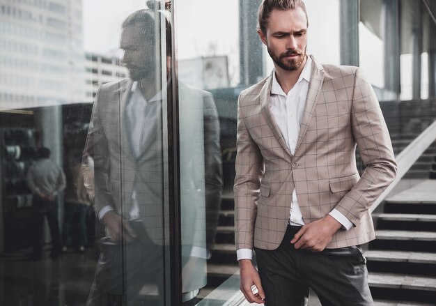 Portrait of sexy handsome man dressed in elegant beige checkered suit