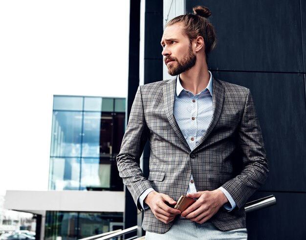 Portrait of sexy handsome man dressed in elegant gray checkered suit