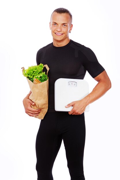 Portrait of sexy man posing in studio with vegetables