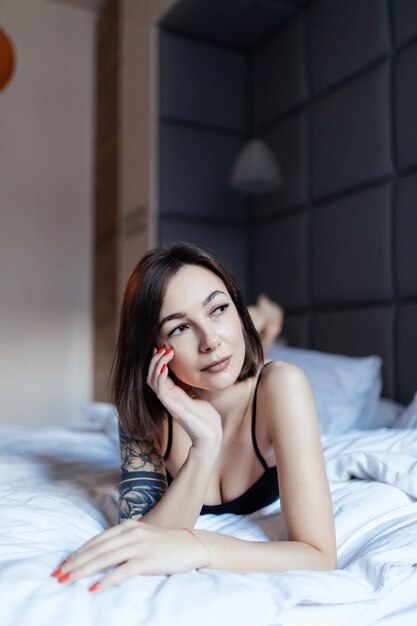 Портрет сексуальная молодая леди в постели рано утром