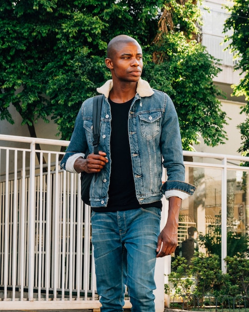 Portrait of shaved african young man with backpack at outdoors