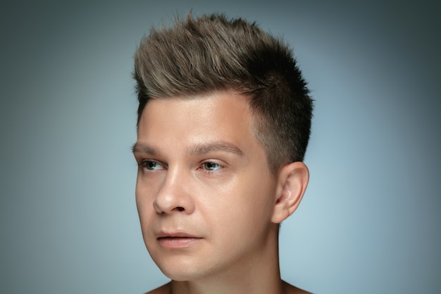 Portrait of shirtless young man isolated on grey  background.