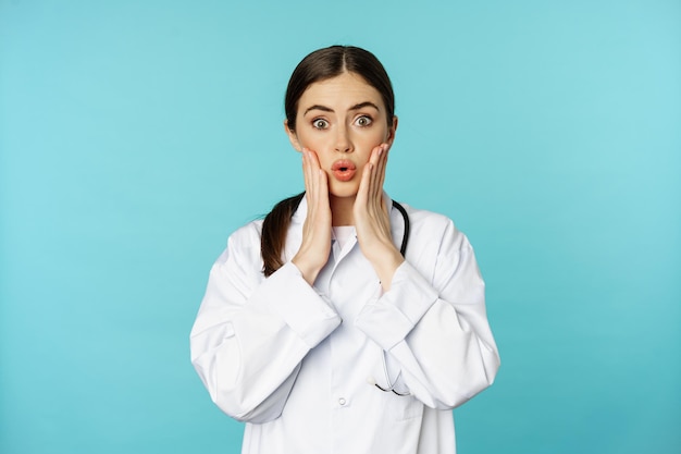 Portrait of shocked female doctor worried healtcare worker in white robe looking concerned at patien...