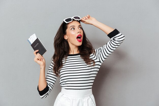 Portrait of a shocked woman holding passport