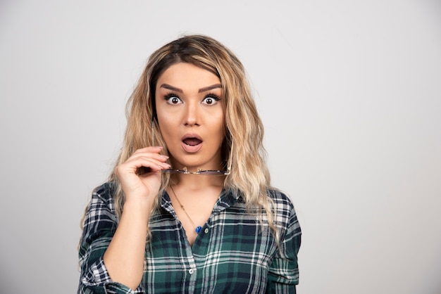 Free photo portrait of shocked woman posing with stylish glasses.