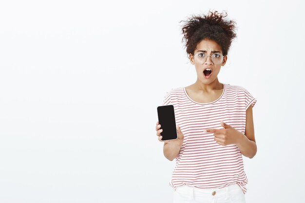 Portrait of shocked woman with afro hairstyle posing in the studio