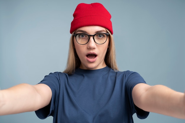 Ritratto di una giovane donna scioccata che si fa un selfie