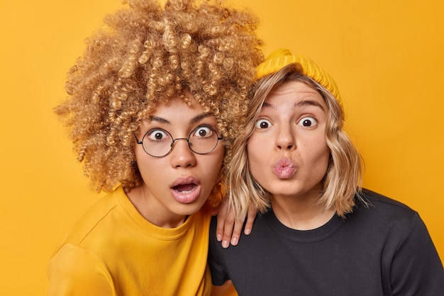 Free photo portrait of shocked young women stare impressed keep mouth opened lips rounded cannot believe in amazing news dressed casually isolated over vivid yellow background human reactions concept