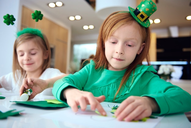 Portrait of siblings making ornament at irish party