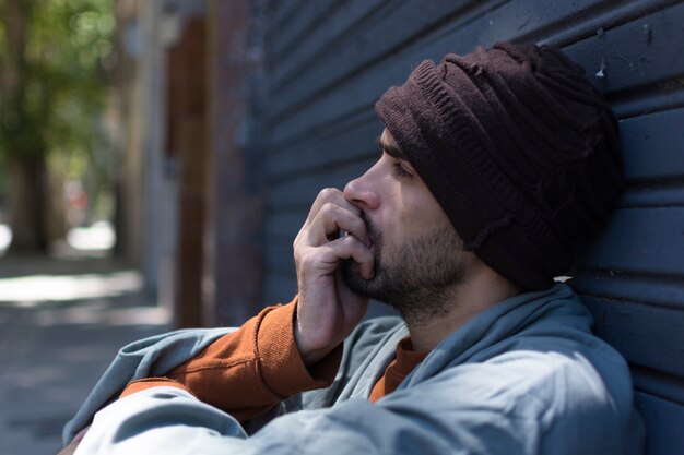 Portrait of sideways homeless man being upset
