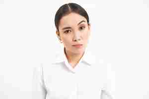 Free photo portrait of skeptical asian woman looks unamused and serious at camera stands isolated on white back