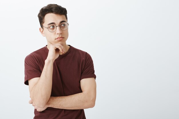 Portrait of smart creative male entrepreneur in t-shirt and round glasses