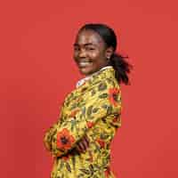 Free photo portrait of smiley african woman in floral coat