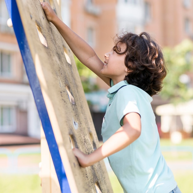 Free photo portrait smiley boy climbing