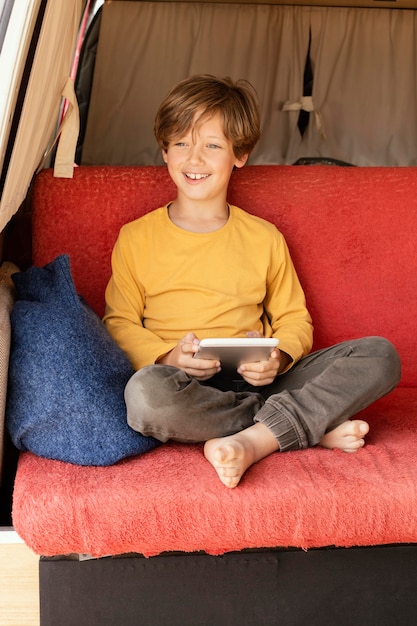 Portrait smiley boy using tablet