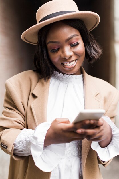 彼女の電話で見ているスマイリーのファッショナブルな女性の肖像画