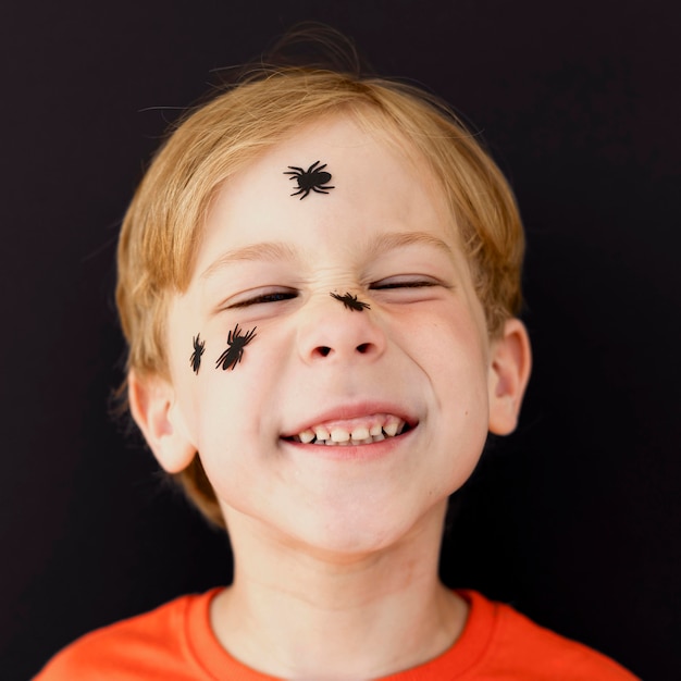 Portrait of smiley kid with face painted for halloween