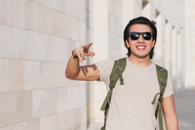 Free photo portrait smiley man showing peace sign