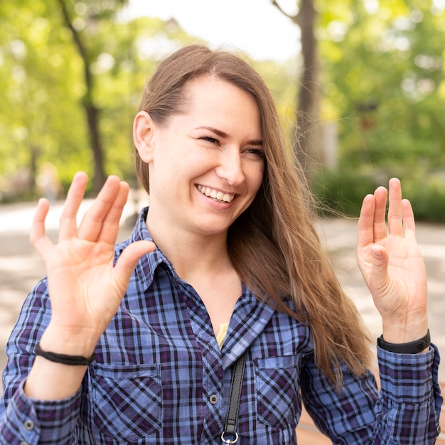 Foto gratuita ritratto della donna di smiley che comunica attraverso il linguaggio dei segni