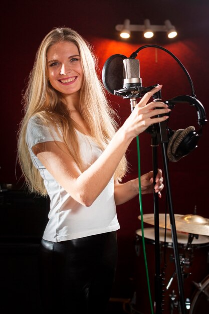 Portrait of a smiley woman holding a microphone stand