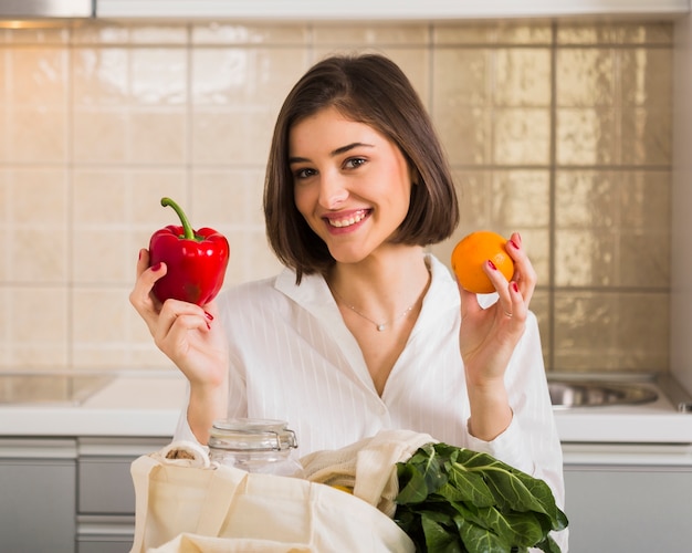 Portrait of smiley woman holding organic groceries