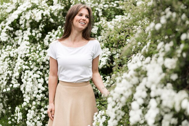 Portrait smiley woman looking at flowers