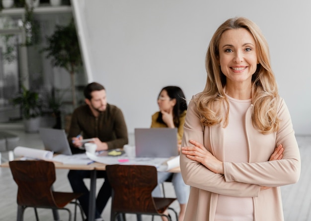 Portrait of smiley woman posing next to her colleagues