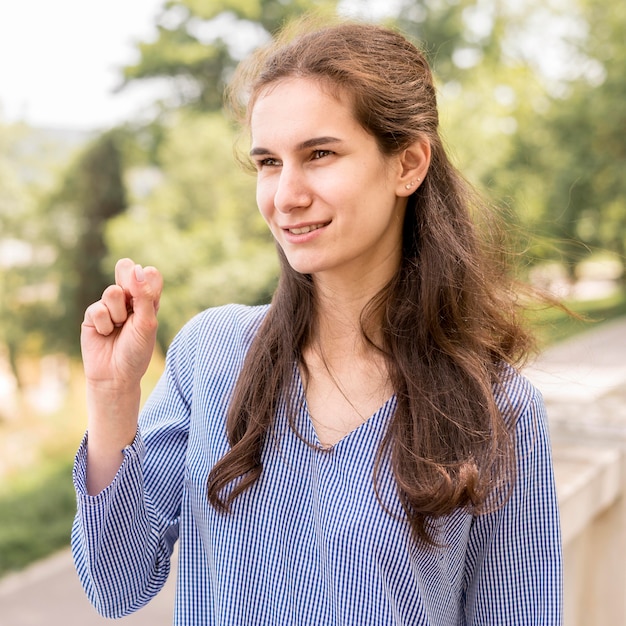 Portrait of smiley woman teaching sign language