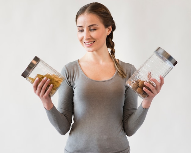 Free photo portrait of smiley young woman holding jars