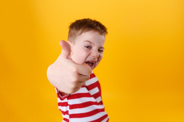 Free photo portrait of a smiling active little boy showing thumbs up