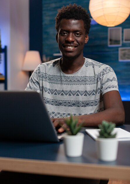 Портрет улыбающегося афро-американского предпринимателя, просматривающего управленческую информацию