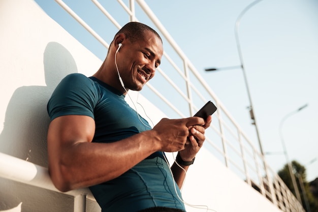 Free photo portrait of a smiling afro american sportsman listening to music