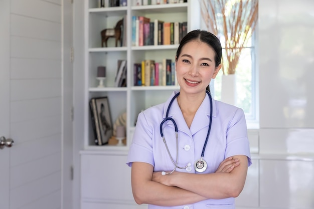 Portrait of a smiling asian nurse looking camera crossing arms