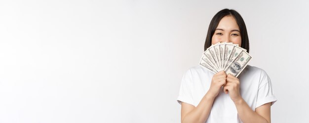 Портрет улыбающейся азиатской женщины, держащей доллары, деньги, концепция микрокредитного финансирования и денежного резерва