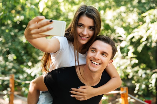 Selfieを作る愛の笑顔の魅力的なカップルの肖像画