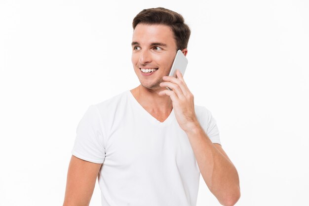Портрет улыбающегося привлекательного мужчины в белой футболке