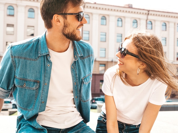 Portrait of smiling beautiful girl and her handsome boyfriend in casual summer clothes and sunglasses.  . Hugging