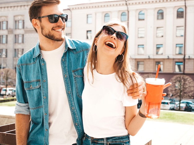 Ritratto di bella ragazza sorridente e il suo bel ragazzo in abiti estivi casual. . donna con bottiglia di acqua e paglia